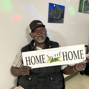 Tunstell holds a Home Sweet Home sign that he recieved as a gift from Residential Options Staff